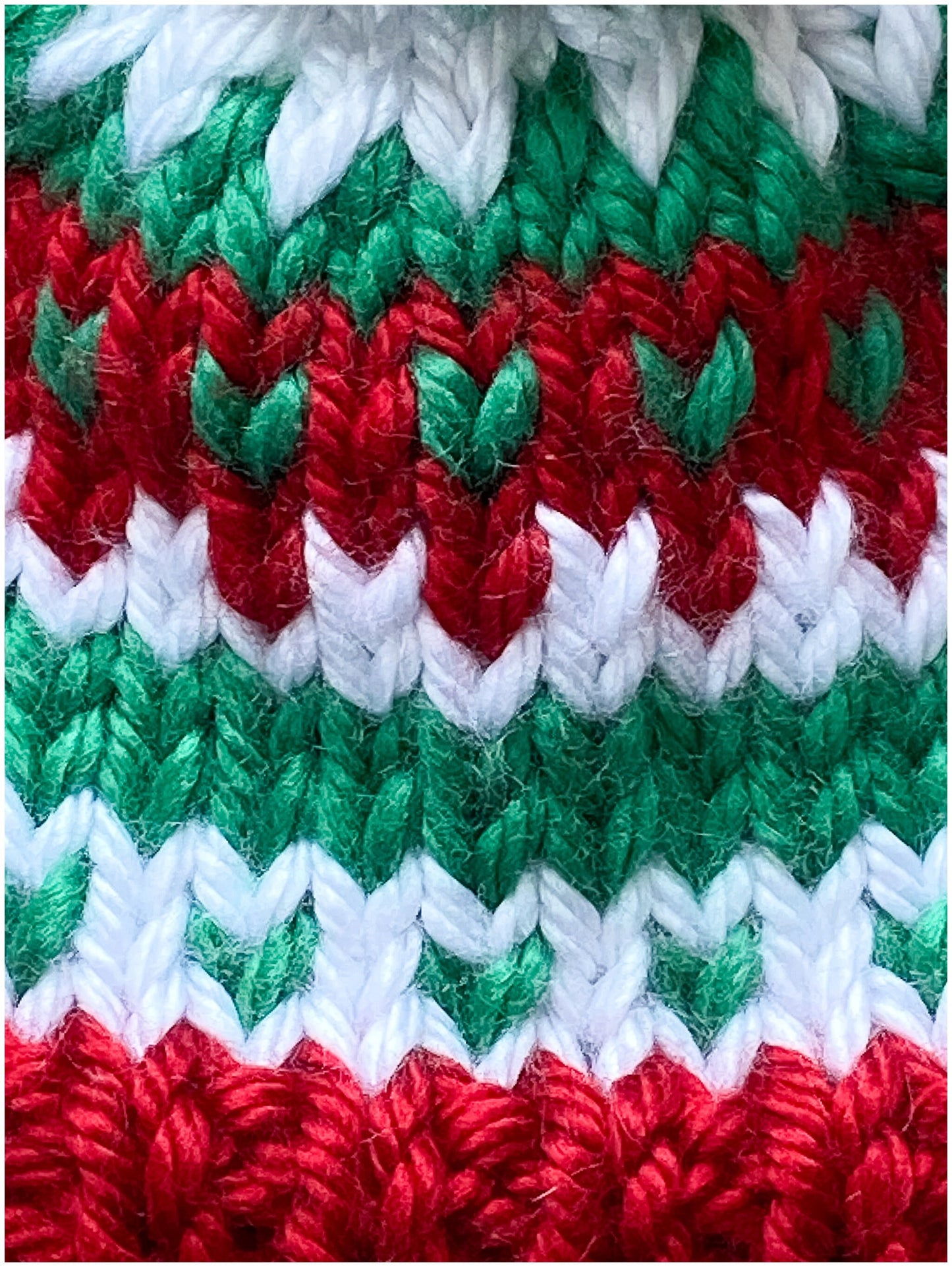 Toddler Christmas hat knit in a fair isle pattern of red and green with white accent color