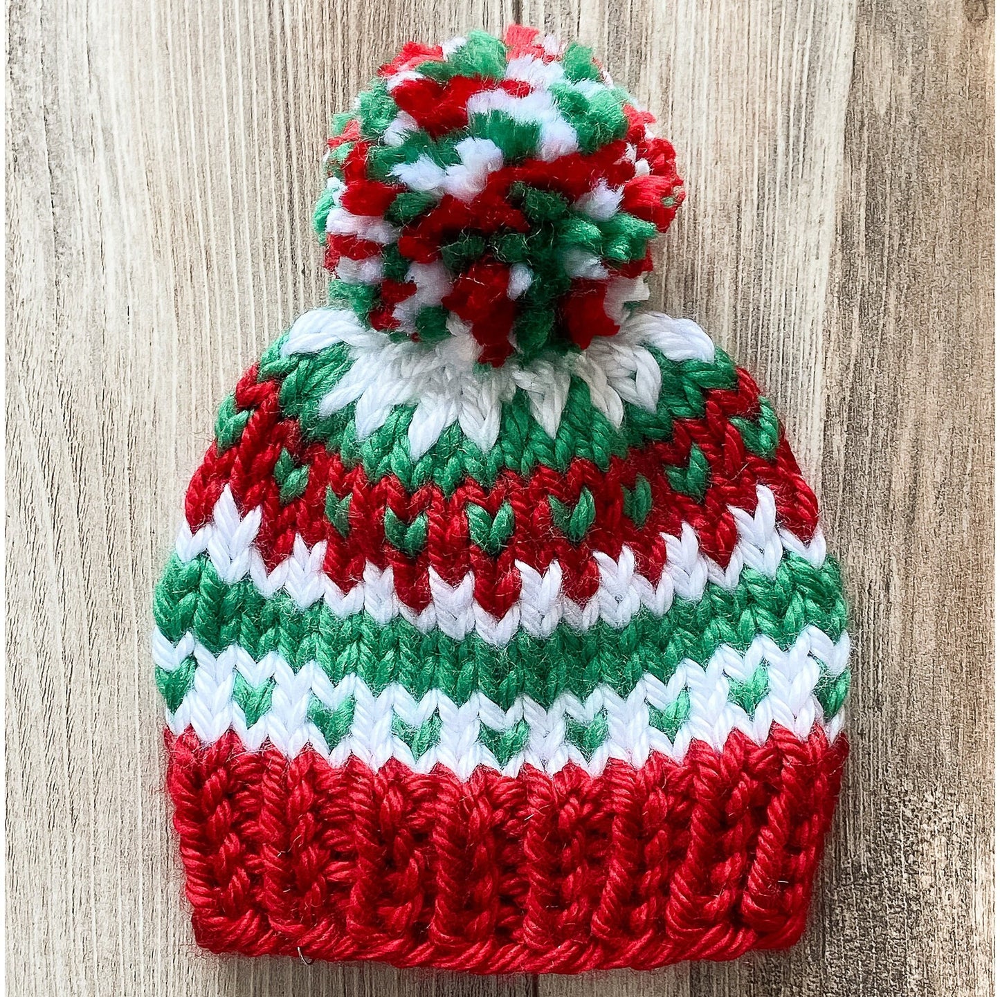 Toddler Christmas hat knit in a fair isle pattern of red and green with white accent color