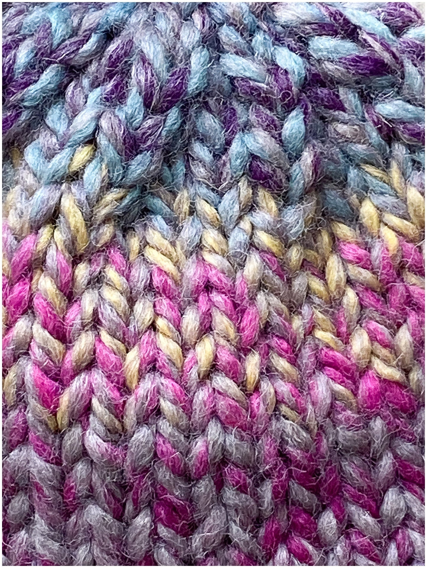 Child's wool beanie hand-knit in a multi-colored yarn with raspberry brim