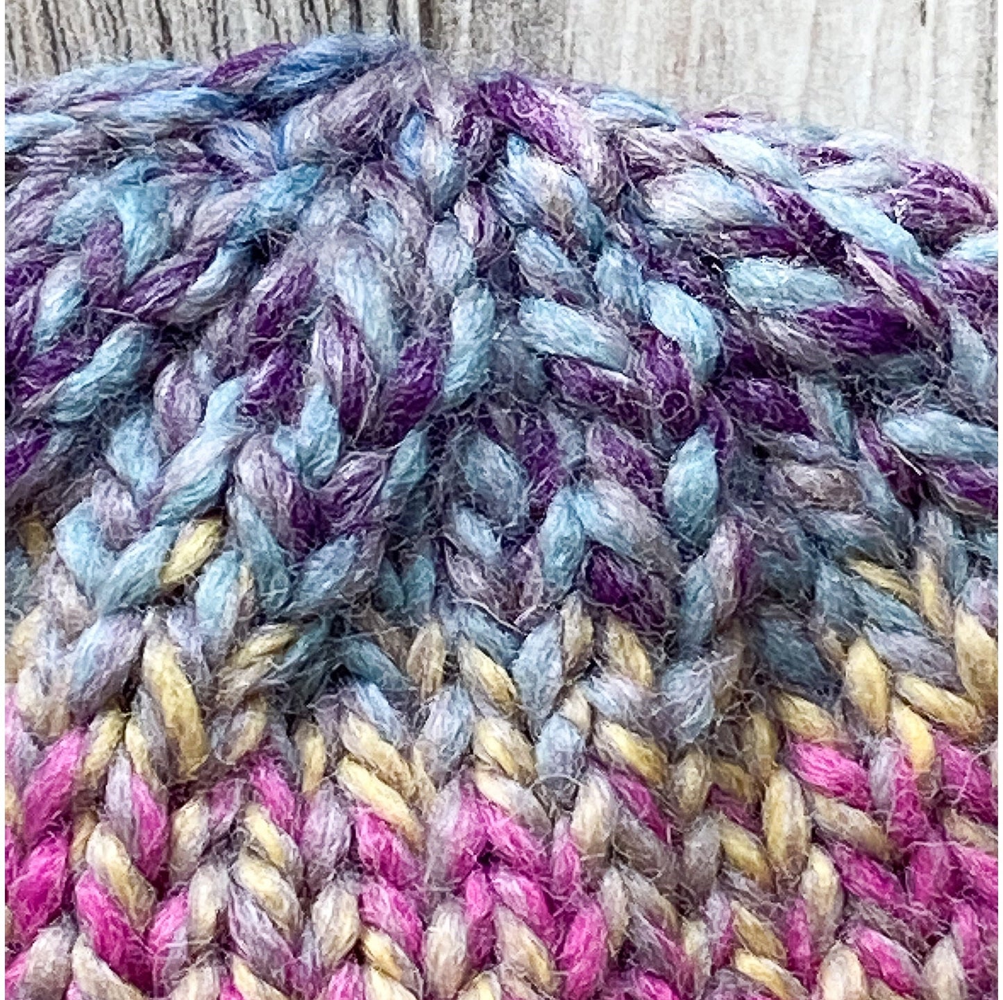 Child's wool beanie hand-knit in a multi-colored yarn with raspberry brim