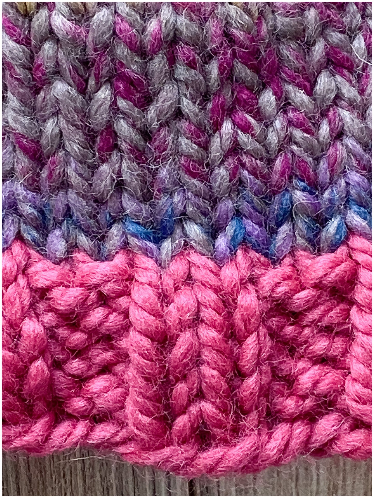 Child's wool beanie hand-knit in a multi-colored yarn with raspberry brim